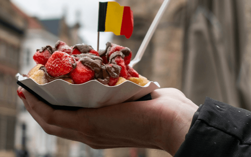 Belgium flag pin over the plate of strawberry dish