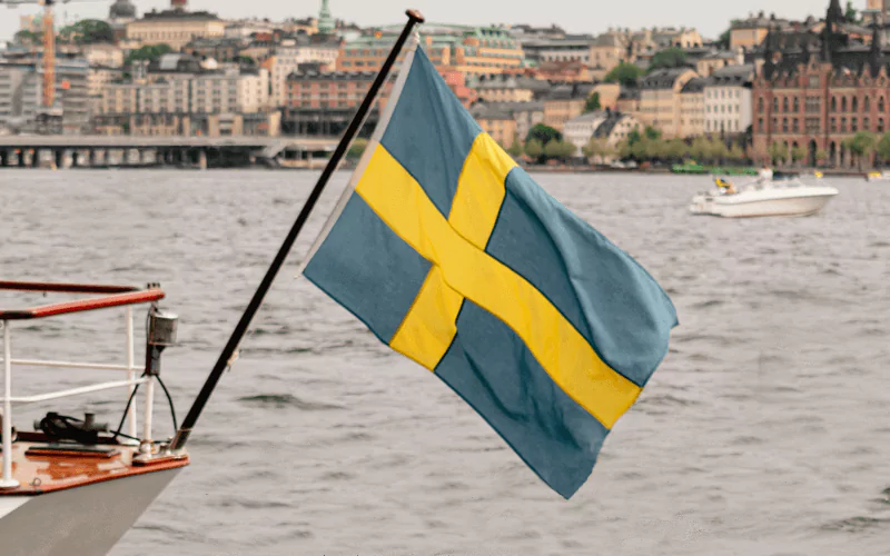 Blue and yellow flag of sweden waving on the boat