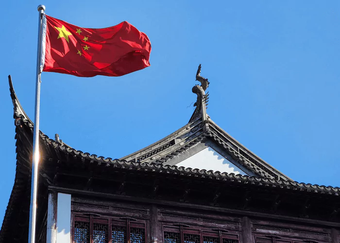 Chinese flag above the traditional sculptured building
