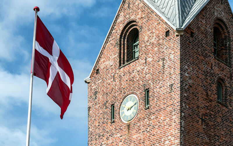 Flag of Denmark infront of clock tower
