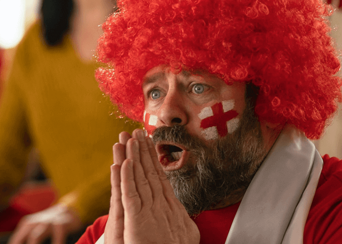 Flag of England painted on the face of excited soccer fans