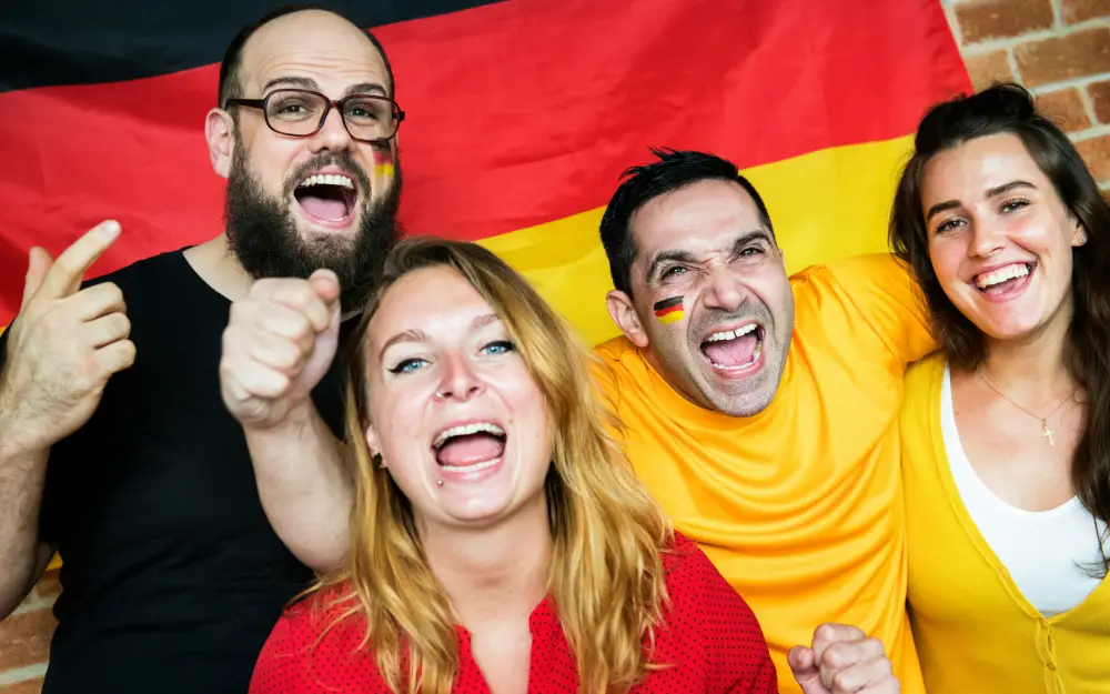 Friends cheering during the match in front of German flag