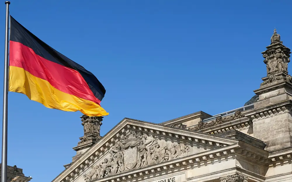 Black, red and yellow German flag besides the historical building