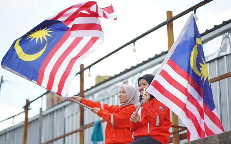 Girls holding Malaysian flags at the stadium