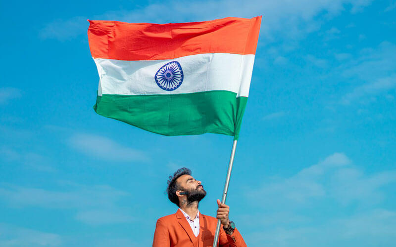Man Holding an Indian Flag fluttering in the sky
