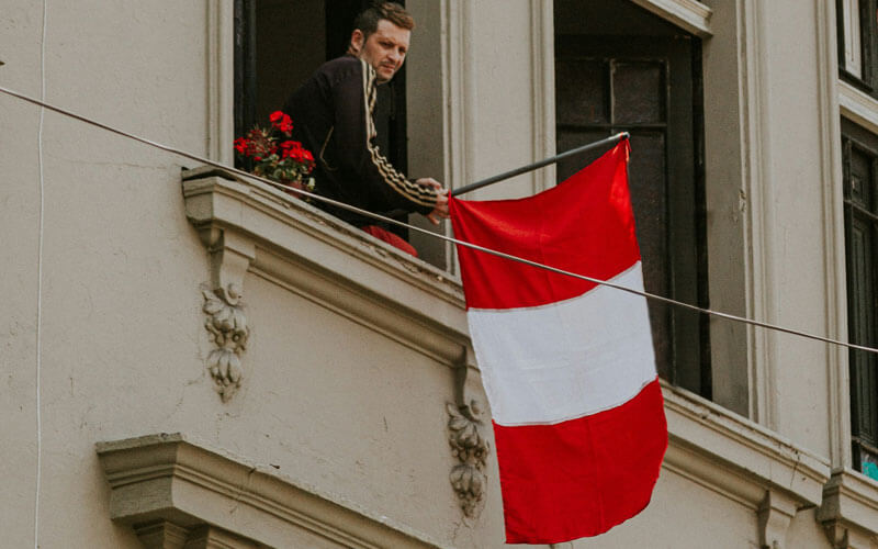 Man waving Peru flag out of the window