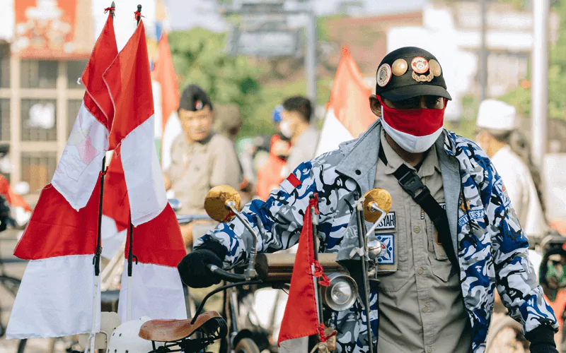 Man with bicycle carrying flags of Indonesia