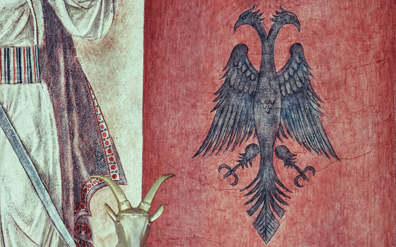 Painting of coat of arms of flag of Albania on red background