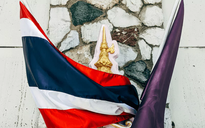 The red, white and blue Thailand flag wrapped around the shield