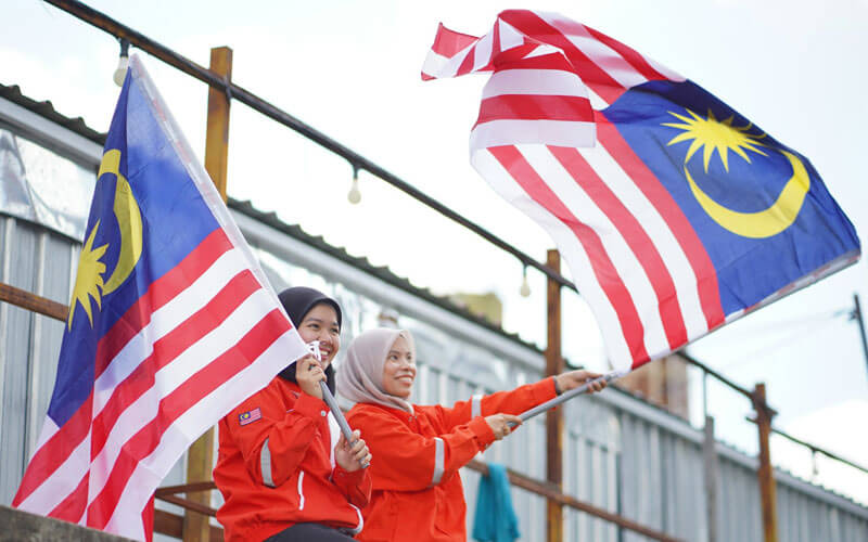 Two Women Holding Malaysian Flags