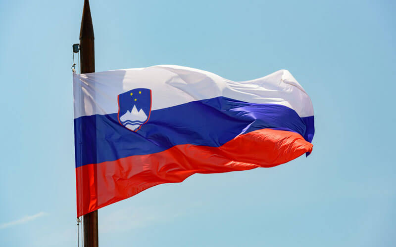 White, blue and red flag of Slovenia flying in the wind