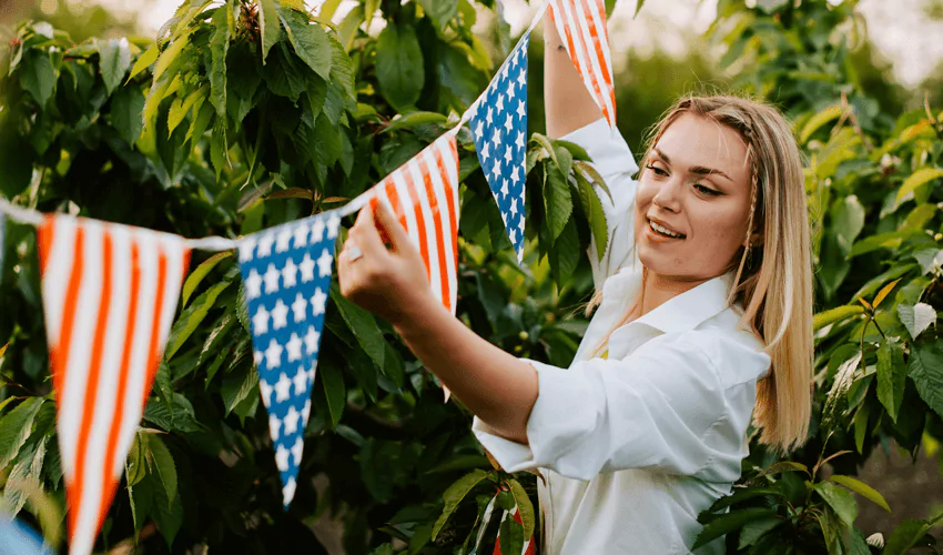 Women celebrating American independence day with string of us flags